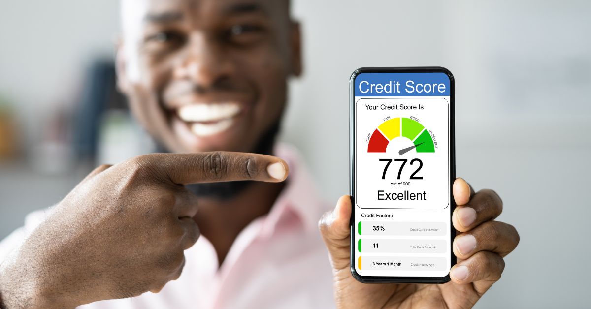 man smiling while checking excellent credit score on phone