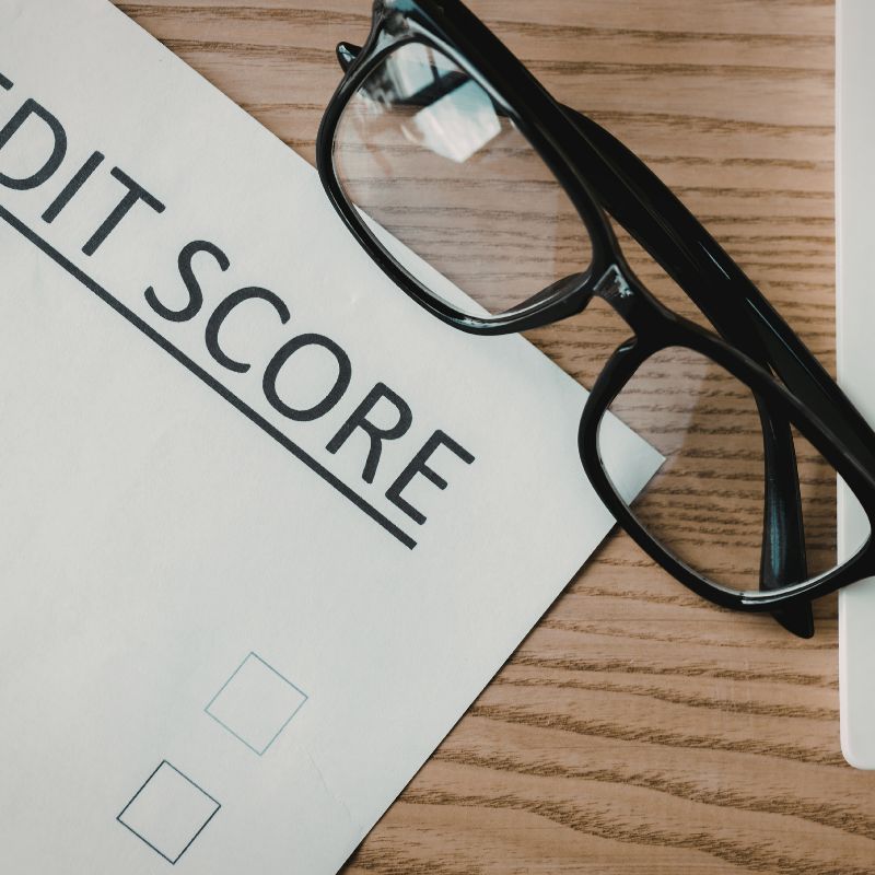 Paper titled Raide your credit score, next to glasses.