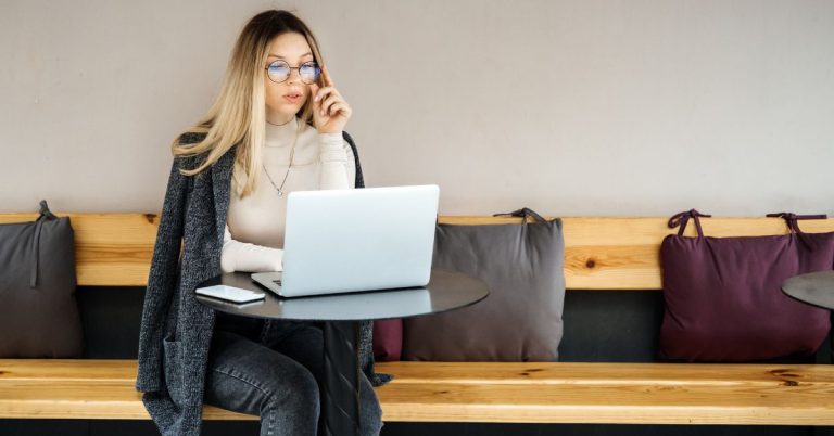 Woman working on laptop — how to design a life that pays you through multiple income streams and smart financial decisions